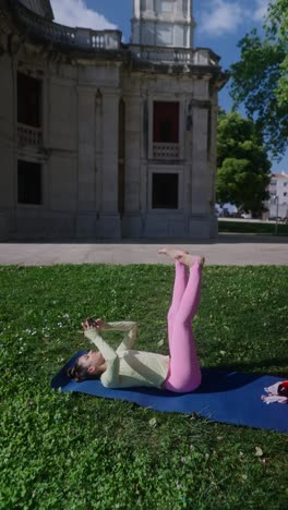 woman practicing yoga outdoors near a building