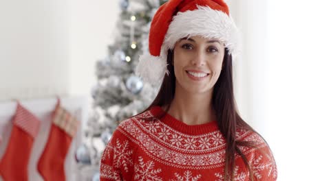 una mujer joven y bonita celebrando navidad en casa.