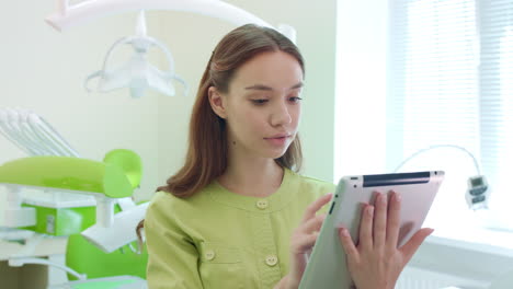 estudiante de medicina trabajando en una tableta en el consultorio dental. mujer médico usando una tableta