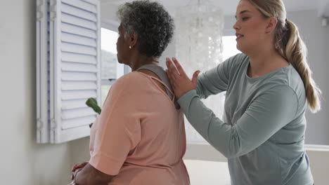 Caucasian-female-physiotherapist-massaging-back-of-senior-woman,-copy-space,-slow-motion