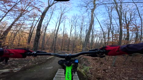mtb rider pov saltando obstáculo de madera en otoño sendero puesta de sol