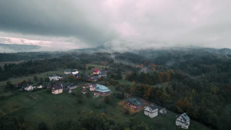 bird eye view of autumn forest in countryside covered by fog and clouds