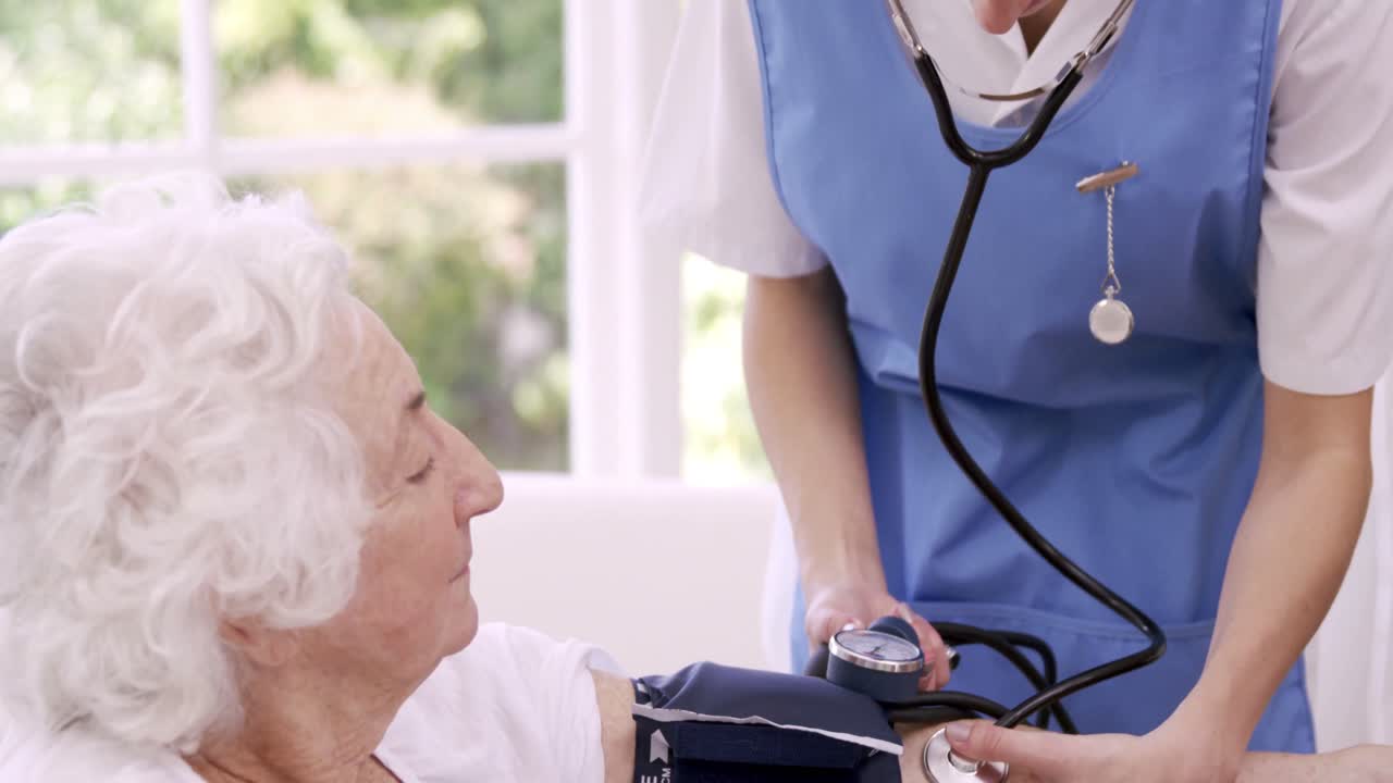 Nurse checking bloody pressure of senior woman