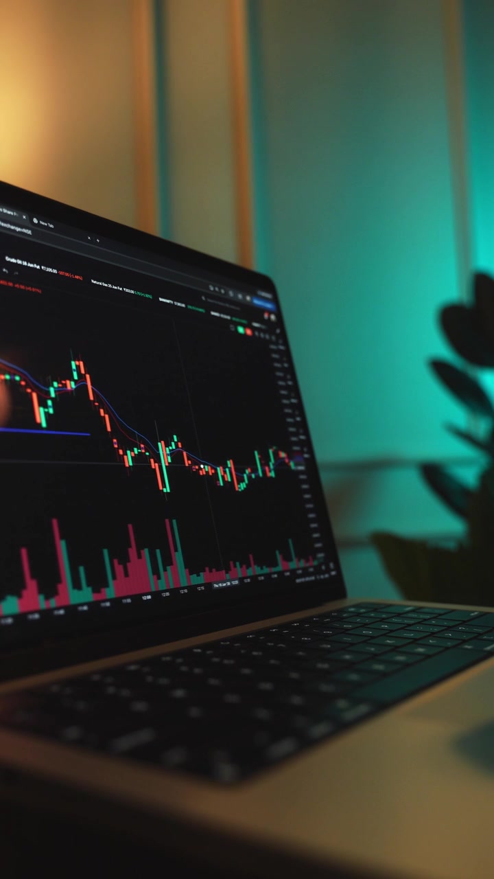 Trader che analizza grafici di borsa su un laptop tramite una piattaforma di brokeraggio