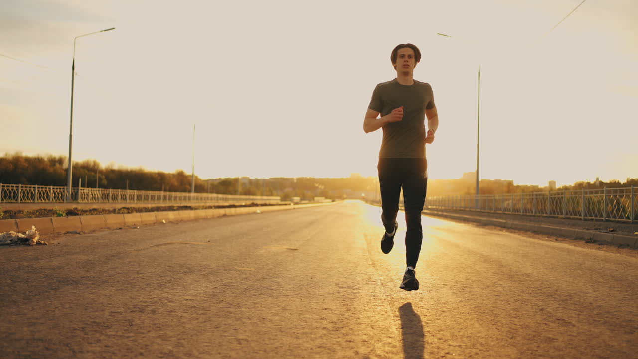 un guapo deportista está corriendo solo en una mañana de verano en una carretera vacía frente a una figura masculina