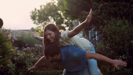 handsome man giving piggy back to his girlfriend