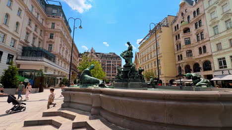vienna, austria - june 9, 2025: tourists in vibrant wien. visitors explore a lively square in wien, admiring historic architecture and a beautifully crafted fountain