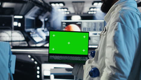 astronauts check human expansion in space mission logs on mockup laptop