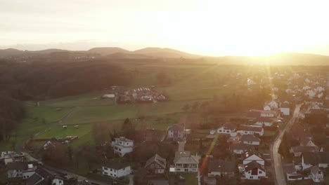 Drone---Toma-Aérea-De-Una-Puesta-De-Sol-De-Un-Pequeño-Pueblo-En-Una-Hermosa-Puesta-De-Sol-De-Color-Vibrante,-Oelberg,-Siebengebirge,-Bonn,-Königswinter-24p