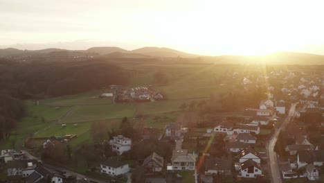 drone - aerial fly away shot of a sunset of a little village at a beautiful, vibrant color sunset, oelberg, siebengebirge, bonn, königswinter 24p