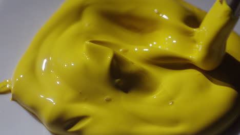 yellow paint on palette with brush