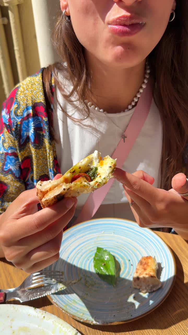 mujer comiendo una rebanada de pizza