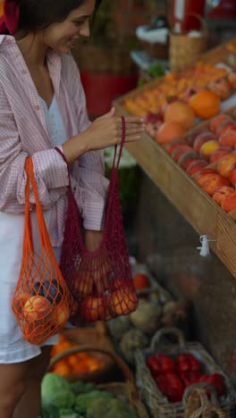 woman shopping for peaches at a farmers market