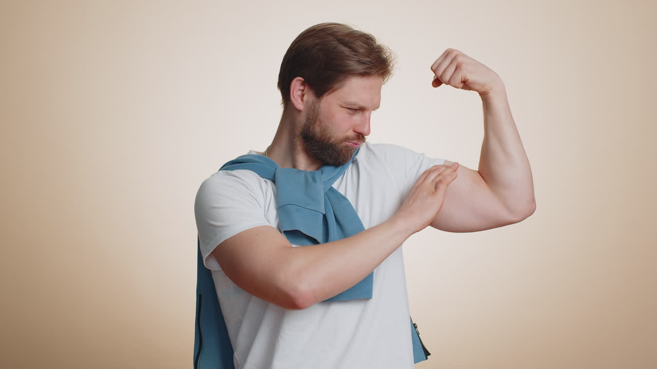 Fit sporty caucasian man showing biceps and looking confident feeling power strength success win