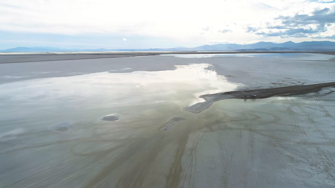 vista aérea de grandes salinas con agua sobre ellas y nubes en el cielo