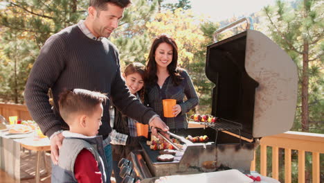 family barbecuing on a deck in the forest