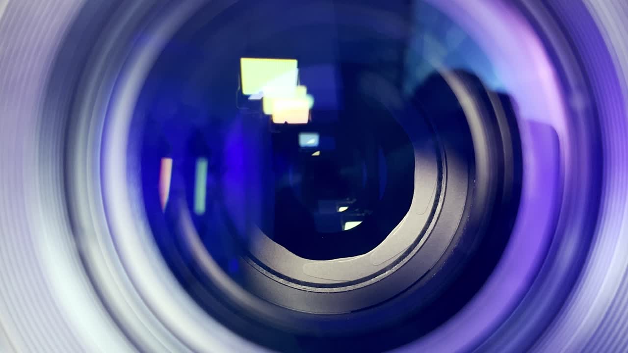 Close-up macro of a camera lens aperture blades opening and closing, showing light reflections and optical elements in motion, concept of photography, focus, and precision