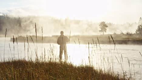 Silhouettenaufnahme-Eines-Fliegenfischers,-Der-Seine-Rute-Auf-Den-Fluss-Wirft