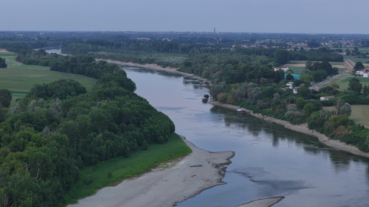 Fiume Po vicino a Isola Serafini, Monticelli d'Ongina, Piacenza, Emilia-Romagna, Italia, che rivela banchi di ghiaia esposti, una ridotta portata del fiume e lo skyline distante di Cremona durante l'ondata di calore del 2026.