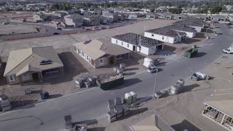 a drone gracefully flies by a newly constructed street, revealing the progress of partially completed home constructions