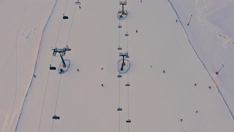 4K-Aerial-Top-Down-Reveal-of-Ski-Lift-Sunset-Winter-Snow-Landscape-Poland