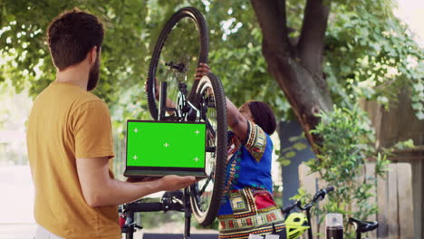 man holds laptop with greenscreen