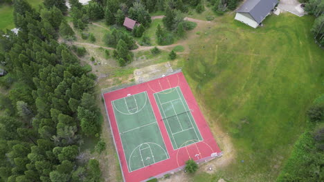 basketball and tennis courts in the woods - aerial view of summer camp outdoor recreation space