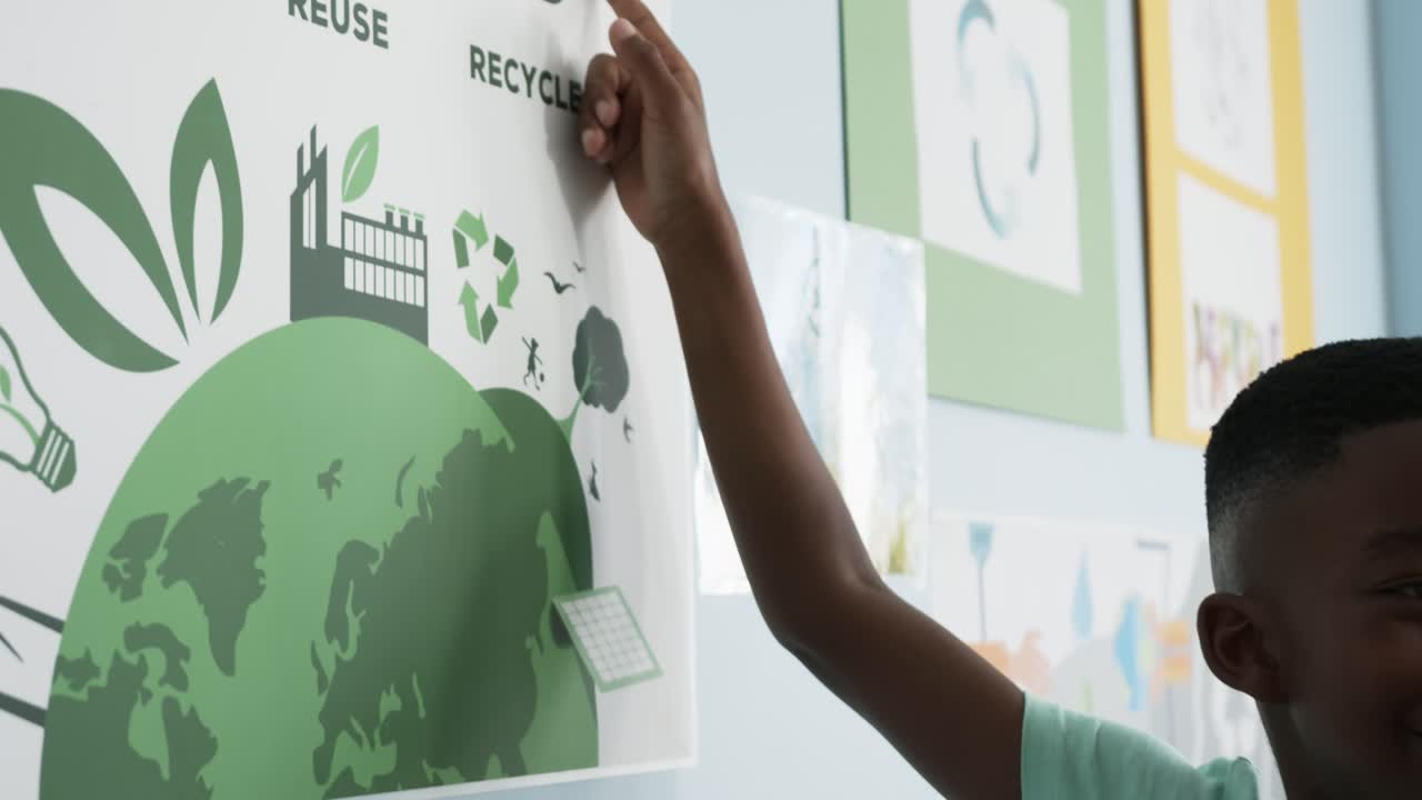 Seeing recycling icon student is reaching up pressing poster on school wall promoting recycling