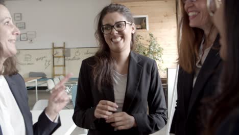 Businesswoman-checking-wristwatch-and-talking-with-colleagues