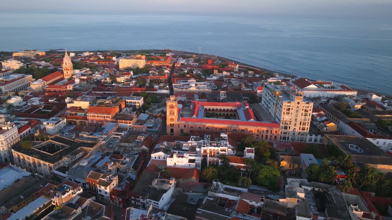 Parallax drone video of the coastline in old town cartagena at sunrise. The sun illuminates over the city capturing the beauty of it, from a aerial view.