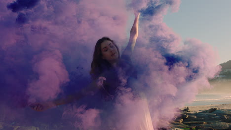 woman dancing with purple smoke bomb on beach celebrating creative expression with playful dance spin in slow motion