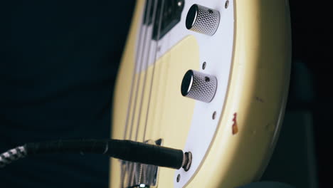 bassist connects jack with output and rotates control knobs