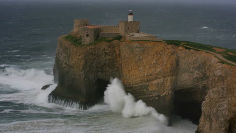 lighthouse and fortress on a cliff with crashing waves