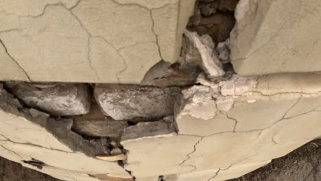 a close-up shot reveals the textured, broken surface of a wall, showcasing cracks and decay in intricate detail.