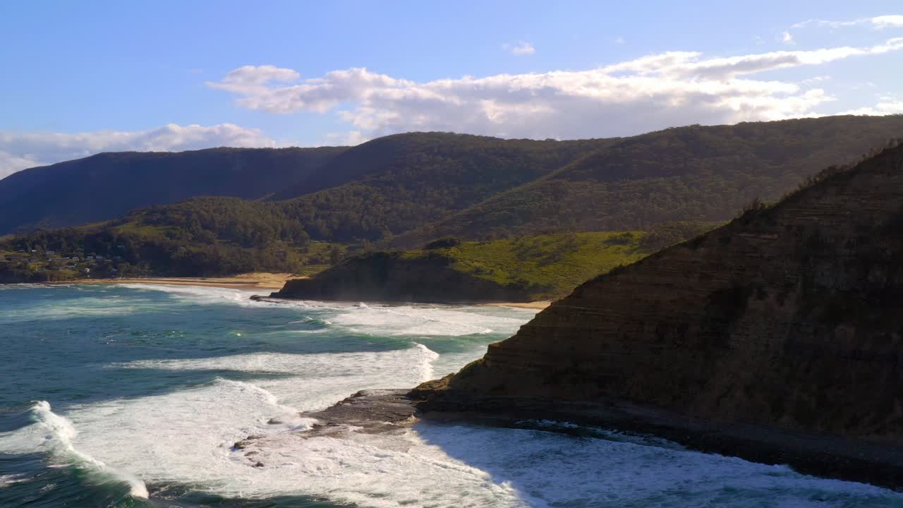 Peak View Of Crashing Waves And Green Mountainside In Royal National Park Australia - aerial shot