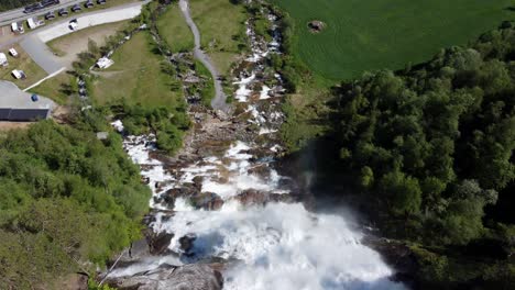 flying over the edge of famous tourist attraction tvindefossen waterfall in voss norway - birdseye aerial from top of waterfall