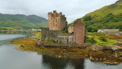 Primer-Plano-De-La-Panorámica-Aérea-Del-Emblemático-Castillo-Escocés-De-Eilean-Donan-En-Las-Tierras-Altas-De-Escocia-En-Un-Día-Nublado-De-Otoño,-Escocia,-Reino-Unido