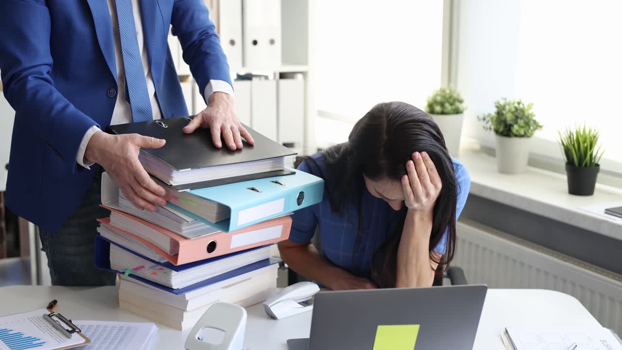 Stressed woman overwhelmed by paperwork in office