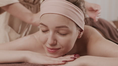 mujer disfrutando de un masaje de espalda en un centro de spa