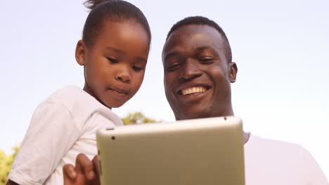 man looking a tablet computer with his daughter