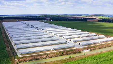 white farm houses on beautiful nature background. modern barns on green field. large territory of agricultural complex in rural place.