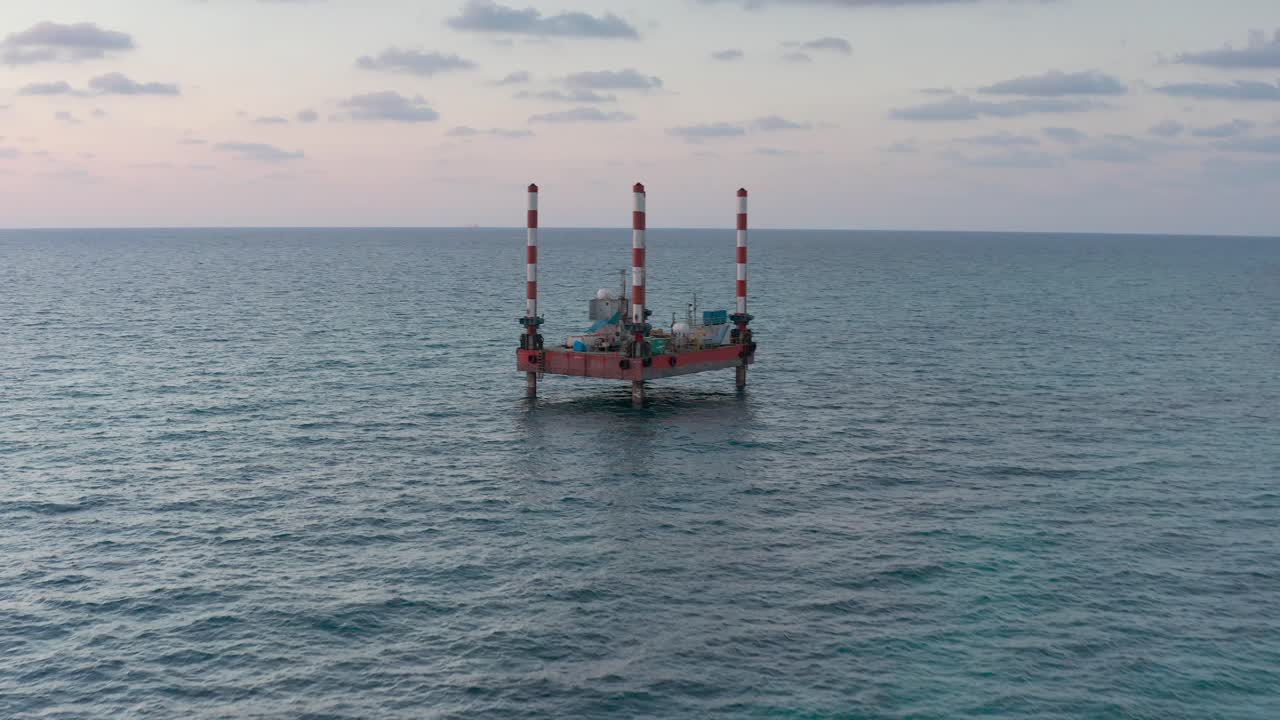 Offshoreplatform i havet ved solnedgang