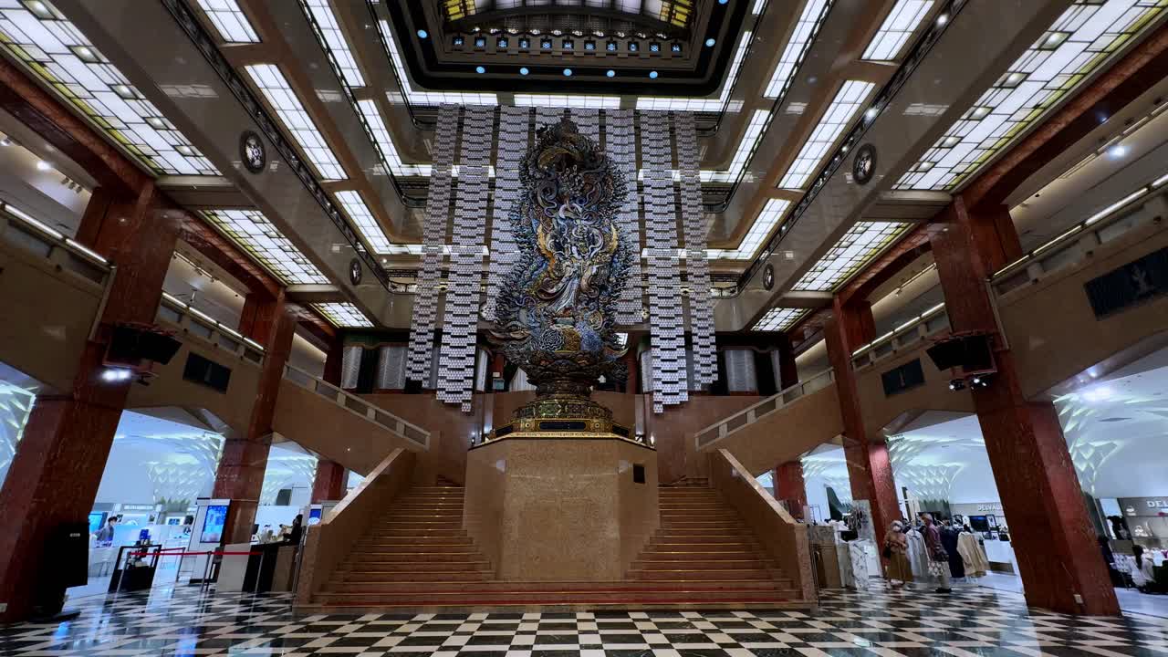 Massive intricate statue in the grand atrium of Ginza Mitsukoshi in Tokyo with bright interior lighting