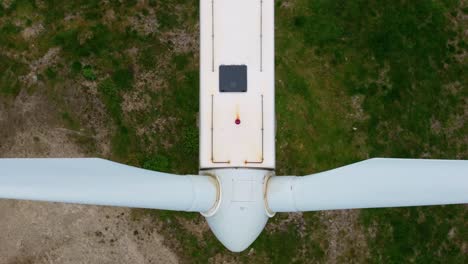una visión general de las palas giratorias de una turbina eólica en el parque eólico de ortegal, a coruña, españa - fotografía aérea de arriba hacia abajo