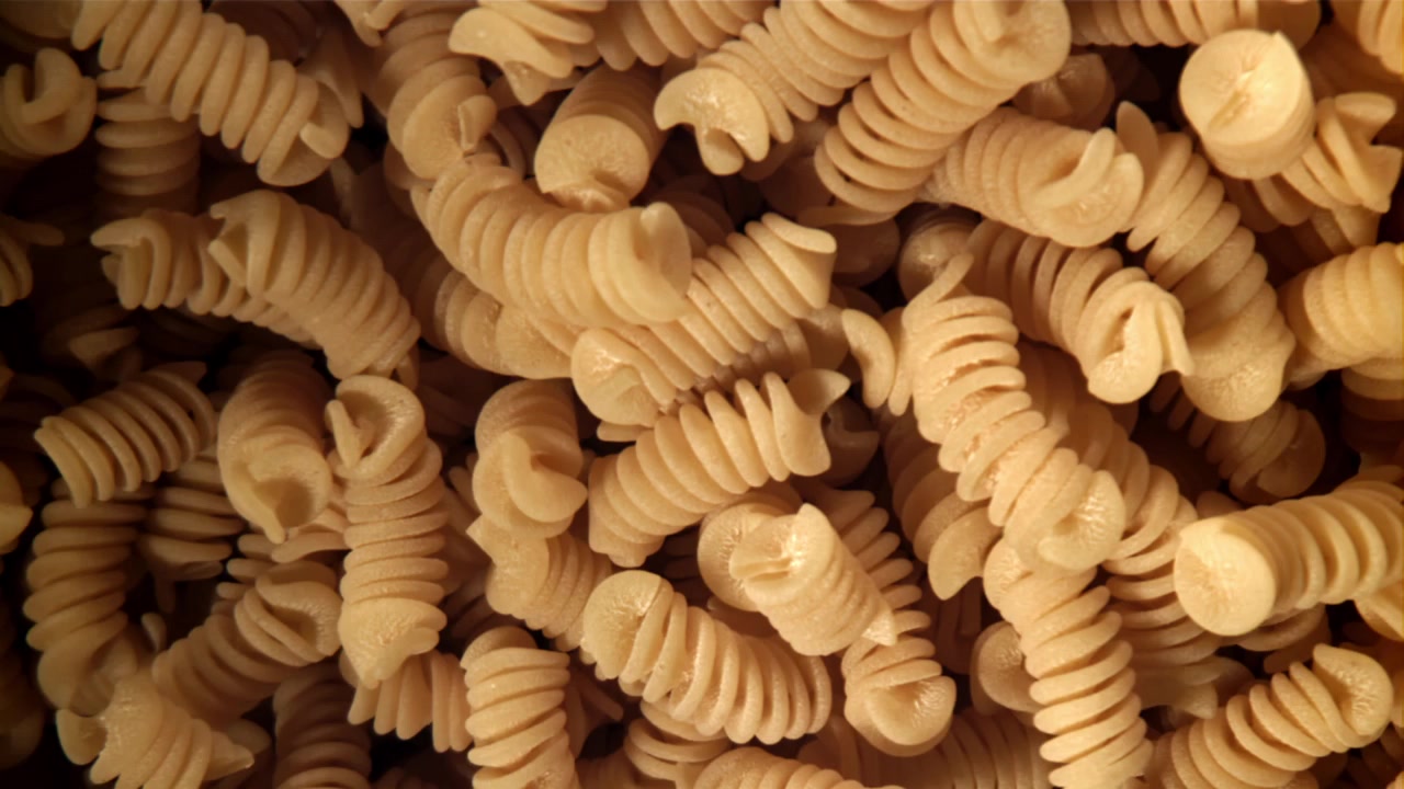 Primo piano di fusilli secchi a spirale con illuminazione dinamica