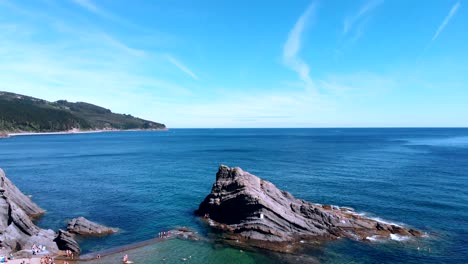 Aerial-cinematic-shot-of-the-Cantabrian-Sea-with-some-plants-in-the-foreground