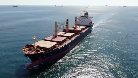impressive close-up of a cargo ship navigating through calm waters, capturing the majestic presence of maritime trade in a vast oceanic landscape