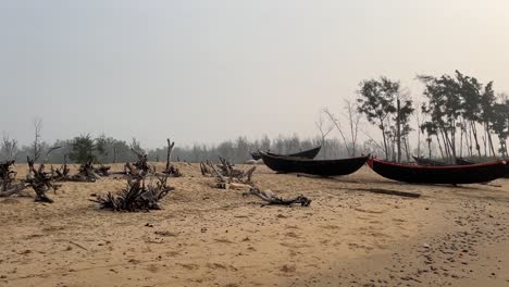 Foto-Panorámica-De-Unos-Pocos-Barcos-Pesqueros-Mantenidos-Cerca-De-La-Costa-En-Una-Playa-Vacía-Y-árida-Durante-La-Puesta-De-Sol-En-Bengala,-India