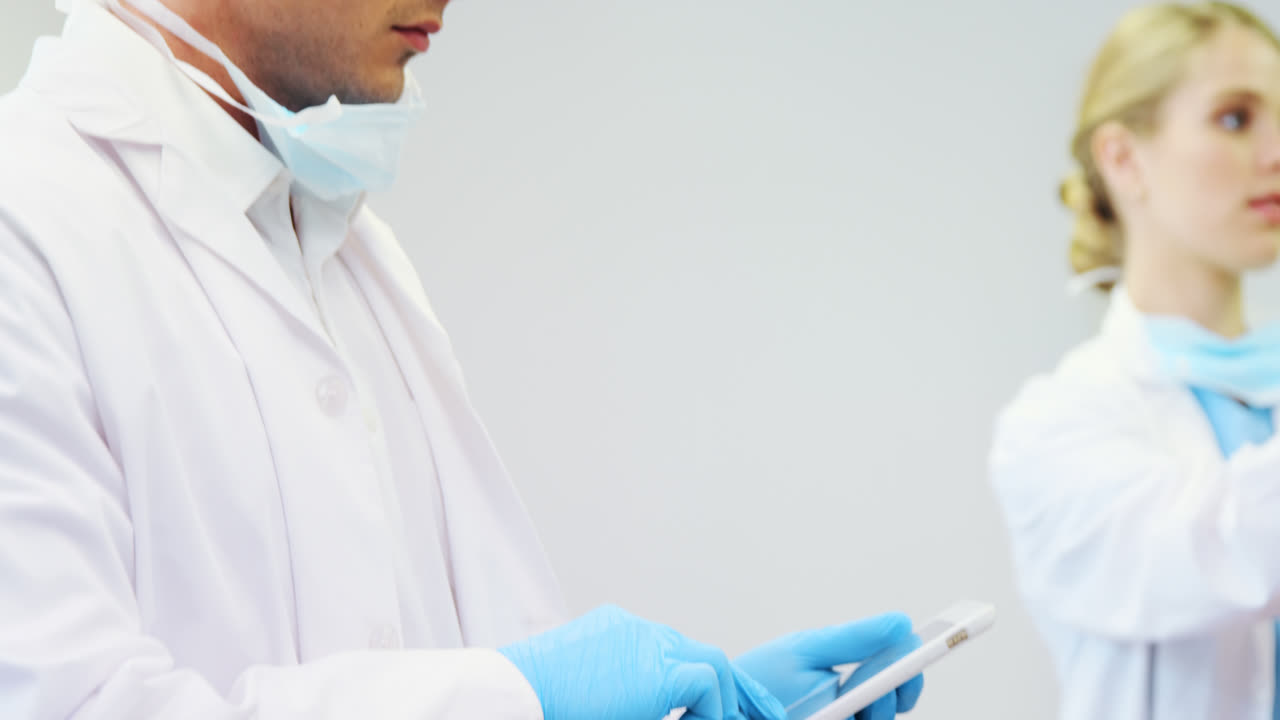 Happy dentist and nurse using digital tablet