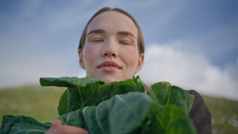 farmer holding leafy cabbage closeup. smiling woman examining green vegetables